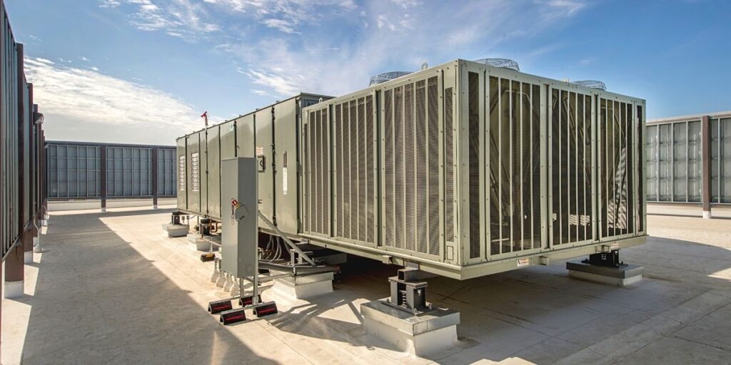 Equipamento industrial com filtro HEPA, sistema de exaustão e conexões pneumáticas em ambiente externo.